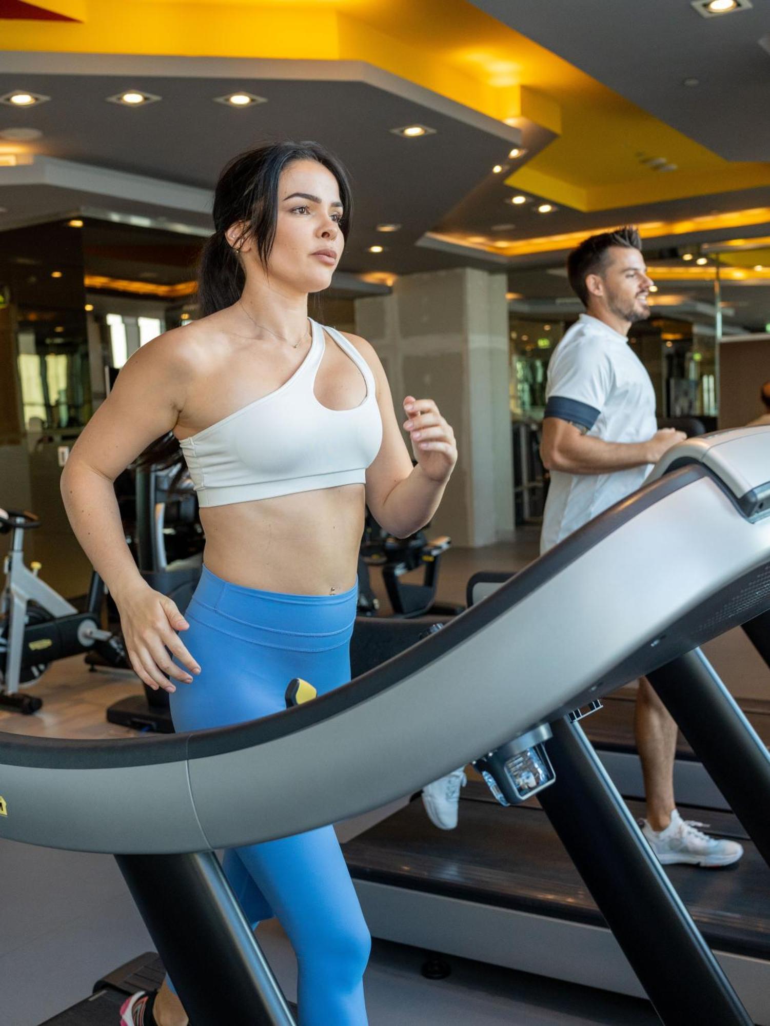 V Hotel Dubai, Curio Collection By Hilton Экстерьер фото A woman and a man on a treadmill